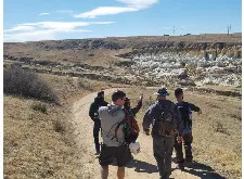 People on hiking trail pointing at mountains