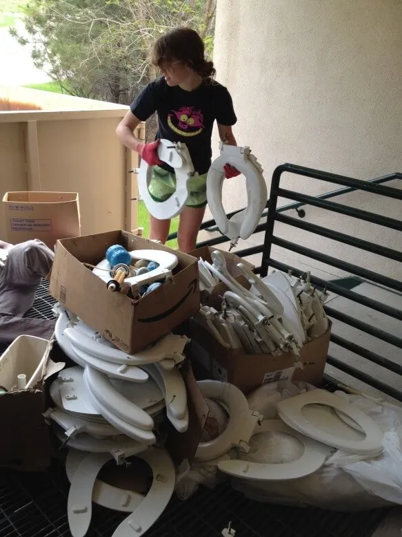 Student helping remove old toilets for the retrofit